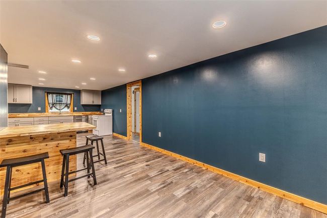 Kitchen with white range with electric stovetop, baseboards, light wood-style floors, recessed lighting, and stainless steel dishwasher | Image 17