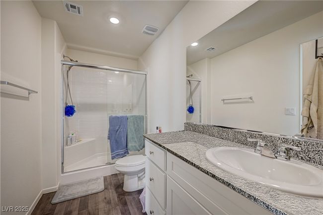 Bathroom featuring wood finished floors, a stall shower, vanity, and recessed lighting | Image 18