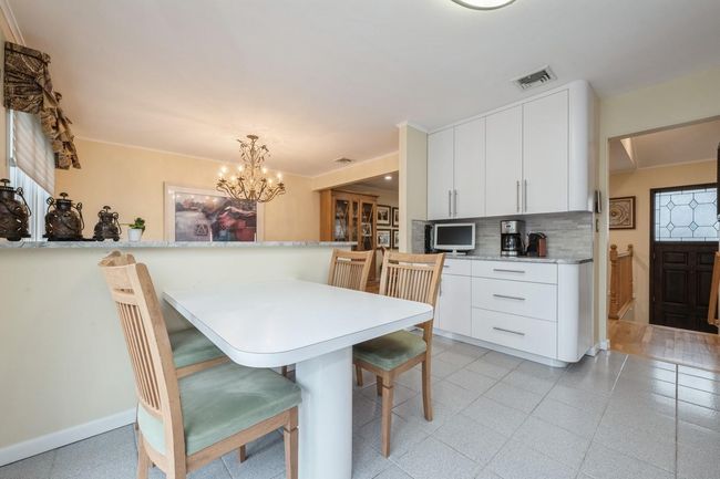 Dining space with baseboards, visible vents, crown molding, and an inviting chandelier | Image 7