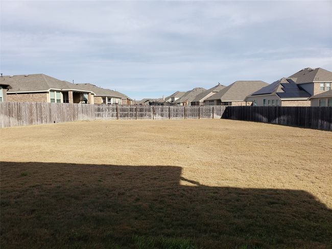 Fenced backyard with a residential view | Image 19