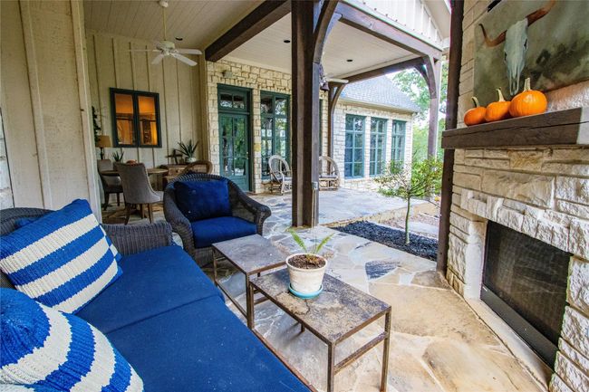 View of patio / terrace featuring an outdoor stone fireplace, french doors, and a ceiling fan | Image 23