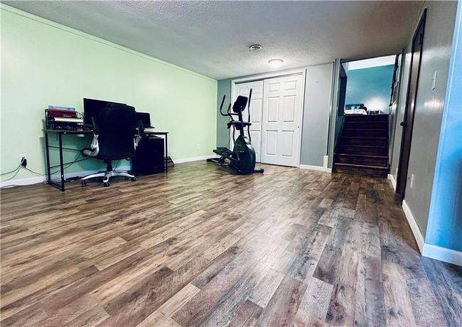Office space featuring wood finished floors, a textured ceiling, and baseboards | Image 21