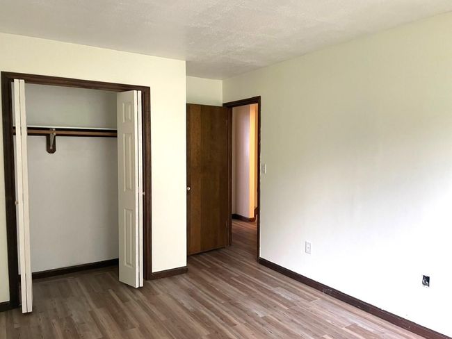 Unfurnished bedroom with wood finished floors and a closet | Image 15