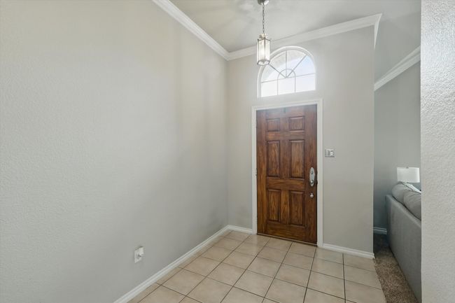 Foyer entrance featuring crown molding, baseboards, and light tile patterned floors | Image 5