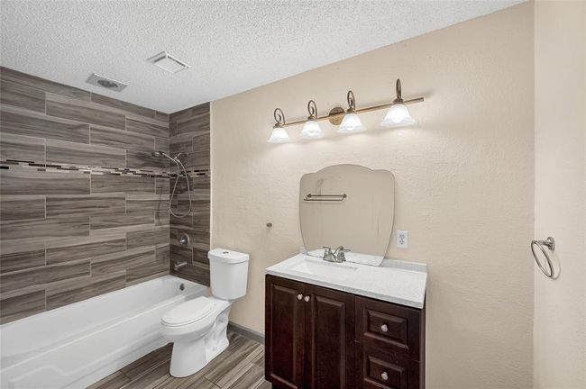 Elegant primary bathroom featuring modern tile accents, a spacious vanity, and a sleek shower-tub combination for ultimate relaxation. | Image 24