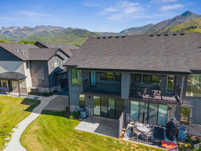 View of front of home with a balcony, a mountain view, a patio area, and stone siding | Image 55