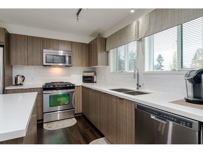 Kitchen with appliances with stainless steel finishes, tasteful backsplash, and a sink | Image 9