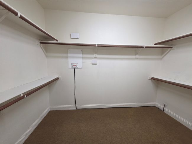 Spacious closet with dark colored carpet | Image 19