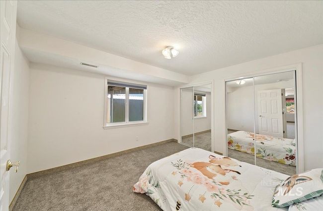 Carpeted bedroom with multiple closets and a textured ceiling | Image 27
