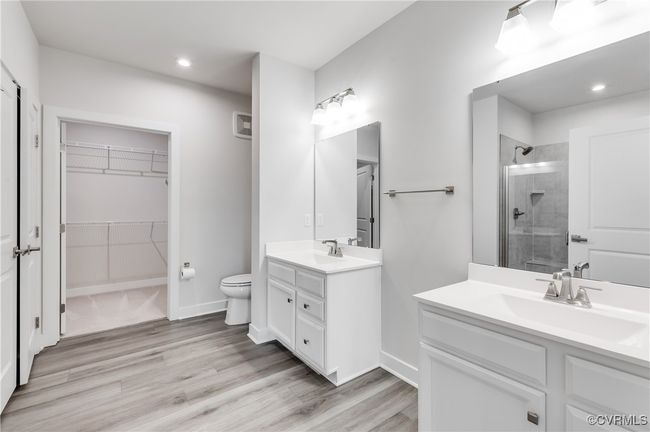 Bathroom featuring a shower stall, vanity, wood finished floors, a walk in closet, and recessed lighting | Image 28
