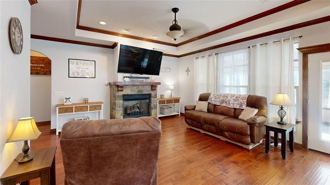 Living room with a fireplace, crown molding, hardwood / wood-style floors, and plenty of natural light | Image 12