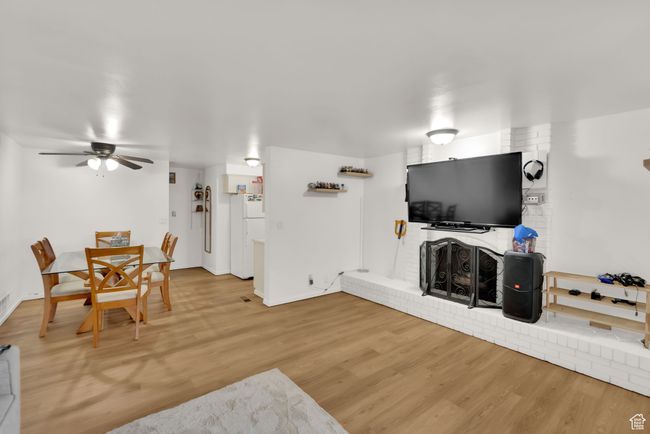 Living area with light wood-style floors and a ceiling fan | Image 9