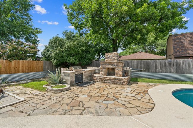 Stainless steel grill, woodburning fireplace, and lots of beautiful plants to enjoy! | Image 25