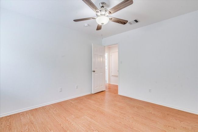 Additional guest bedroom offer wood laminate flooring, a new ceiling fan, and a walk-in closet. | Image 19