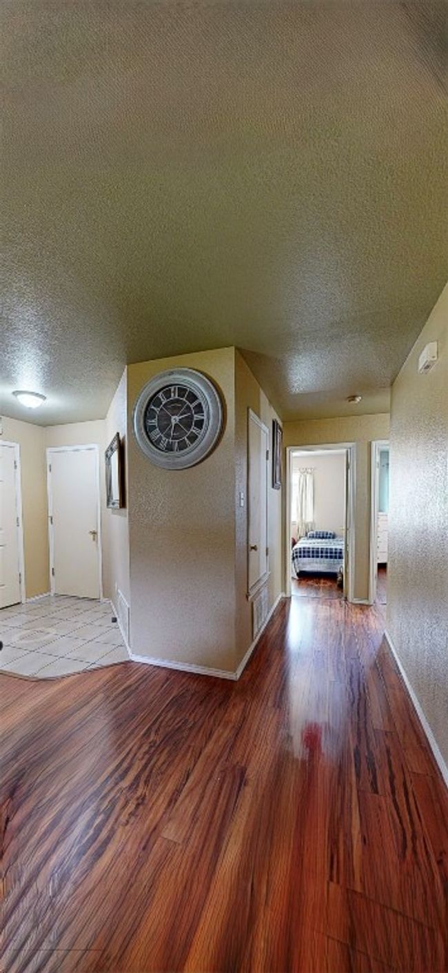 Hallway featuring a textured ceiling and wood finished floors | Image 18