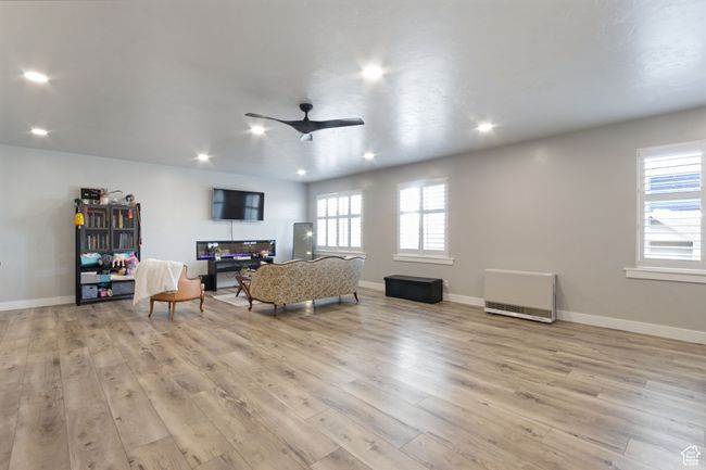 Sitting room with light wood finished floors, a ceiling fan, a wealth of natural light, and recessed lighting | Image 23