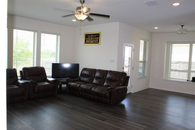Living room with dark wood-style floors, healthy amount of natural light, recessed lighting, a ceiling fan, and baseboards | Image 10