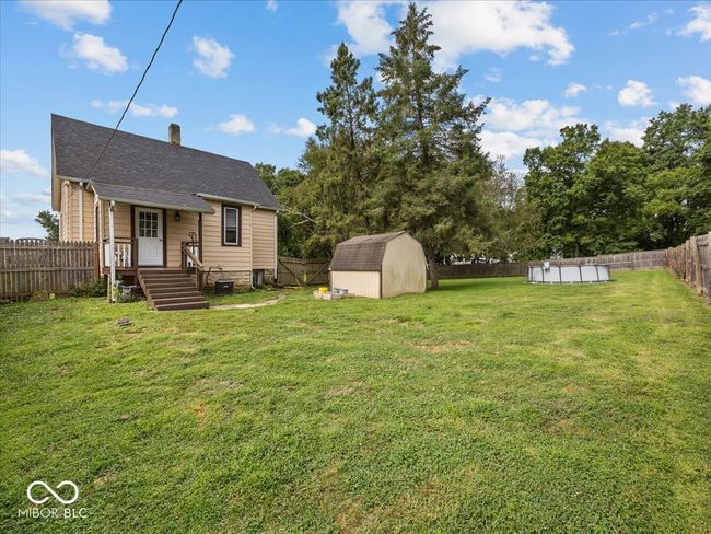 fenced backyard featuring a storage shed | Image 32