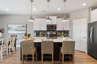 (Photo of decorated model, actual home's finishes may vary slightly) This spacious kitchen features a walk-in pantry, quartz counters, LVP wood floors, stainless appliances and more! | Image 2