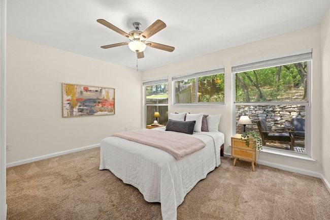 The primary suite features a wall of windows that overlook the serene backyard and includes a private ensuite. | Image 4