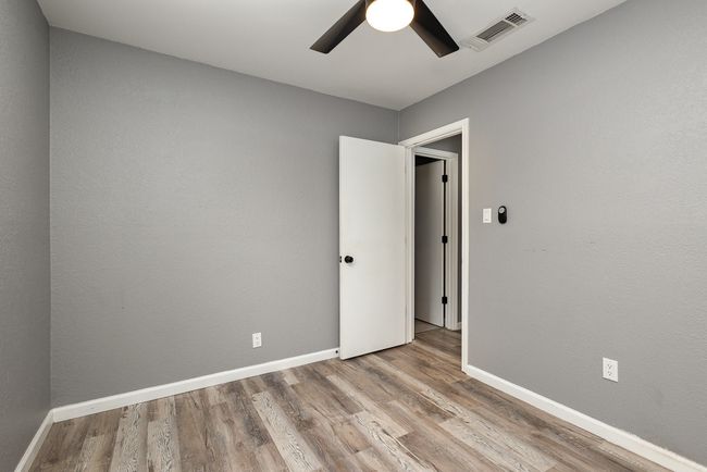 Unfurnished room with ceiling fan, wood finished floors, and baseboards | Image 32