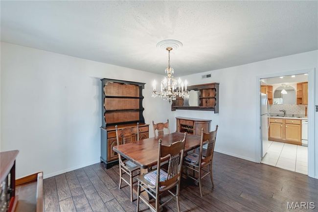 Dining room with hardwood / wood-style flooring and a chandelier | Image 20