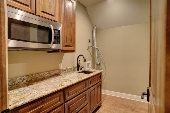 Mini Utility Room off Game Room with room for refrigerator, washer/dryer connections, sink, microwave, and plenty of counter space and cabinets and drawers for storage. | Image 34