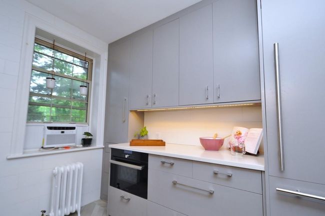 Renovated kitchen has custom cabinets, stainless steel appliances including a stove, dishwasher and steam oven. The refrigerator has matching cabinet door. Other features include a quartz counter, pantry, walk-in closet, under cabinets lighting and herringbone tile floor. | Image 9