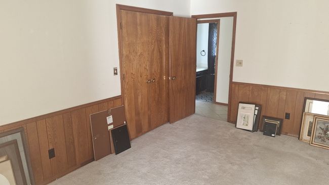 Office featuring a wainscoted wall, wooden walls, and light colored carpet | Image 10