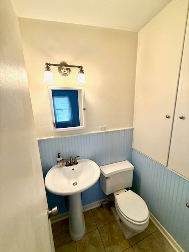 Bathroom featuring toilet, tile patterned floors, and wainscoting | Image 10
