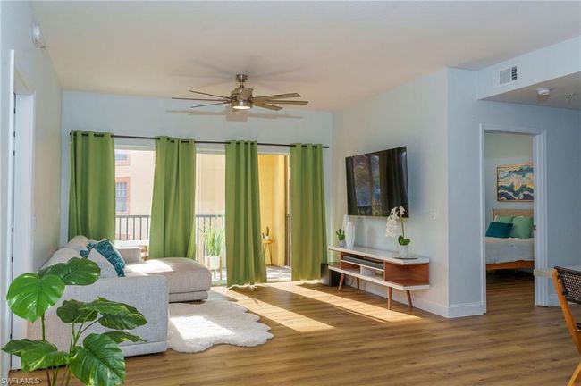 Living room with baseboards, wood finished floors, visible vents, and a ceiling fan | Image 4
