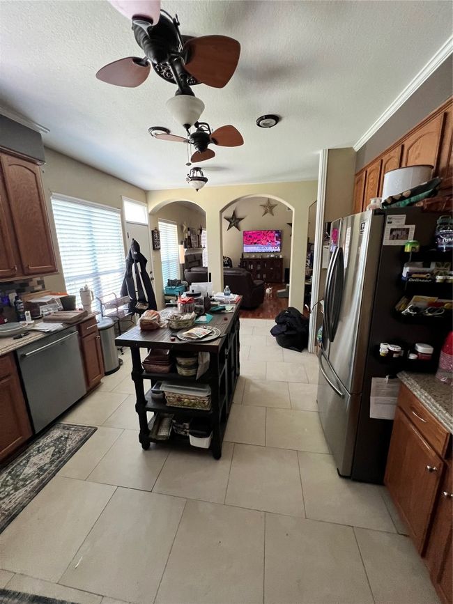 Kitchen with refrigerator, ceiling fan, dishwasher, arched walkways, and a textured ceiling | Image 12