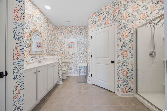 Full bathroom with wallpapered walls, toilet, tile patterned floors, and a stall shower | Image 23