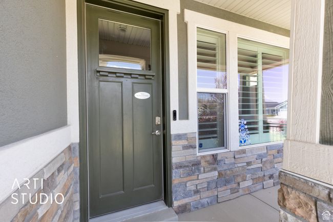 View of exterior entry featuring covered porch, stone siding, and stucco siding | Image 4