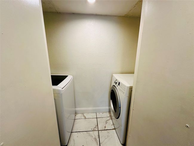 Laundry area featuring washer and dryer, light marble finish flooring, and baseboards | Image 6