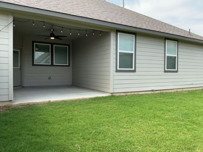Rear view of property with a ceiling fan, a patio, a lawn, and a shingled roof | Image 34
