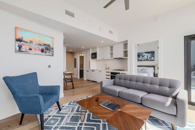 Living area with ceiling fan, visible vents, and light wood finished floors | Image 5