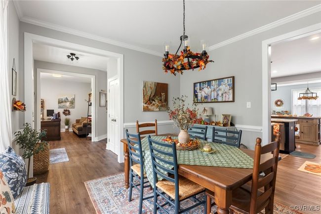 Dining space featuring crown molding, an inviting chandelier, and wood finished floors | Image 10