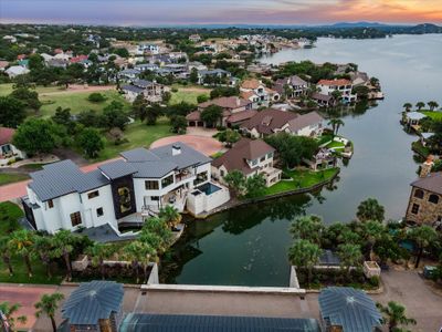 Stunning luxury waterfront home featuring a pristine stucco exterior, expansive outdoor living spaces, and a sparkling pool. Enjoy seamless access to deep water from your private dock, perfect for boating enthusiasts. Experience unparalleled views and upscale living in this exclusive waterfront retreat. | Image 1