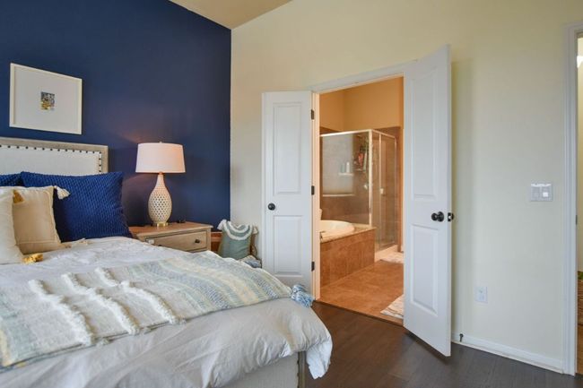 Bedroom with connected bathroom, baseboards, and dark wood-type flooring | Image 14
