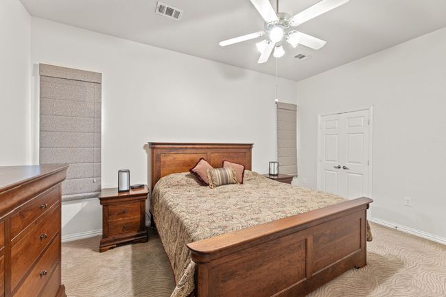 Bedroom with light colored carpet, a ceiling fan, and baseboards | Image 30