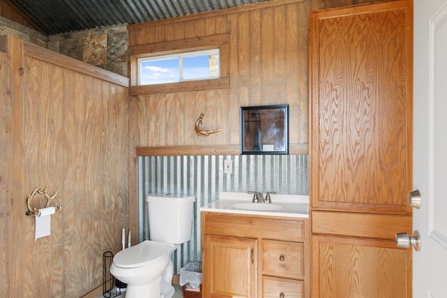 Bathroom featuring wood walls, vanity, and toilet | Image 22