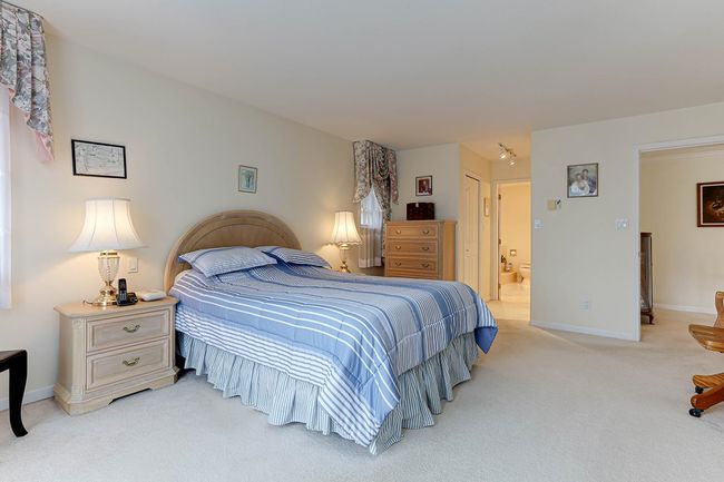 Bedroom featuring baseboards, connected bathroom, and light colored carpet | Image 27