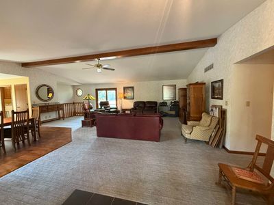 Carpeted living room with ceiling fan and vaulted ceiling with beams | Image 3