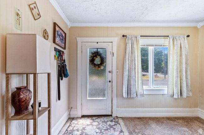 Foyer entrance with ornamental molding, baseboards, carpet, and a textured ceiling | Image 4