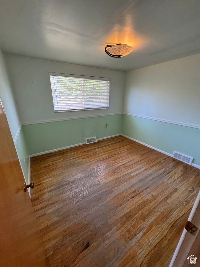 Unfurnished room featuring wood finished floors and baseboards | Image 11