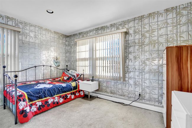 Carpeted bedroom with a baseboard heating unit | Image 25