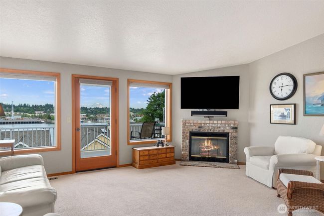 Beautiful views from the bank of windows in the living room. Door leads to large deck. Cozy gas fireplace. | Image 10