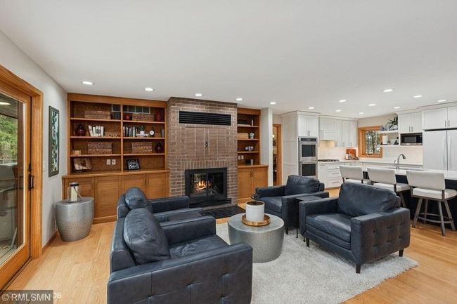 Built ins in the family room with wood burning fireplace. | Image 17