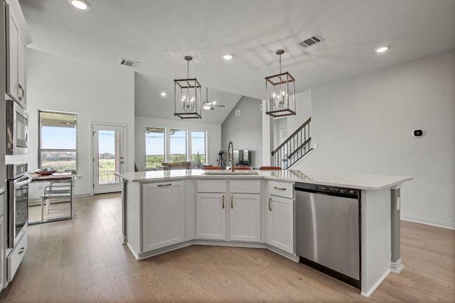 Kitchen with appliances with stainless steel finishes, light countertops, light wood-style floors, recessed lighting, and decorative light fixtures | Image 8